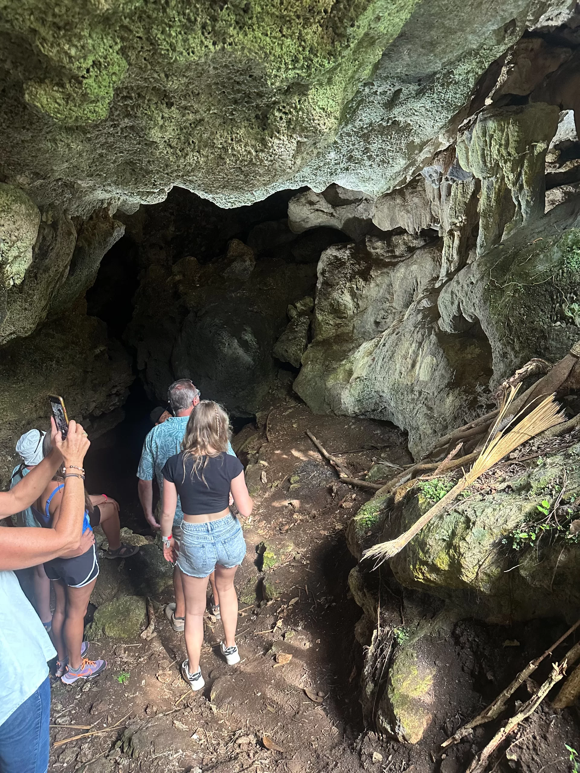 Four KIK visitors taking photos and entering a cave on the property.