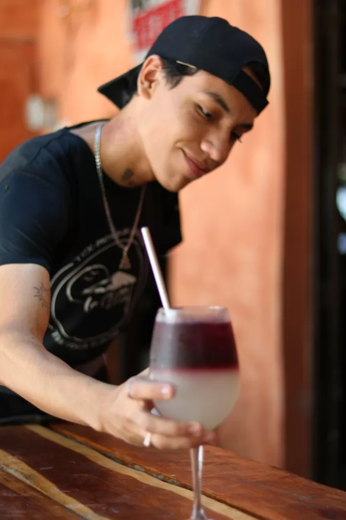 Bartender at La Choza del Puerto serving a delicious cocktail.