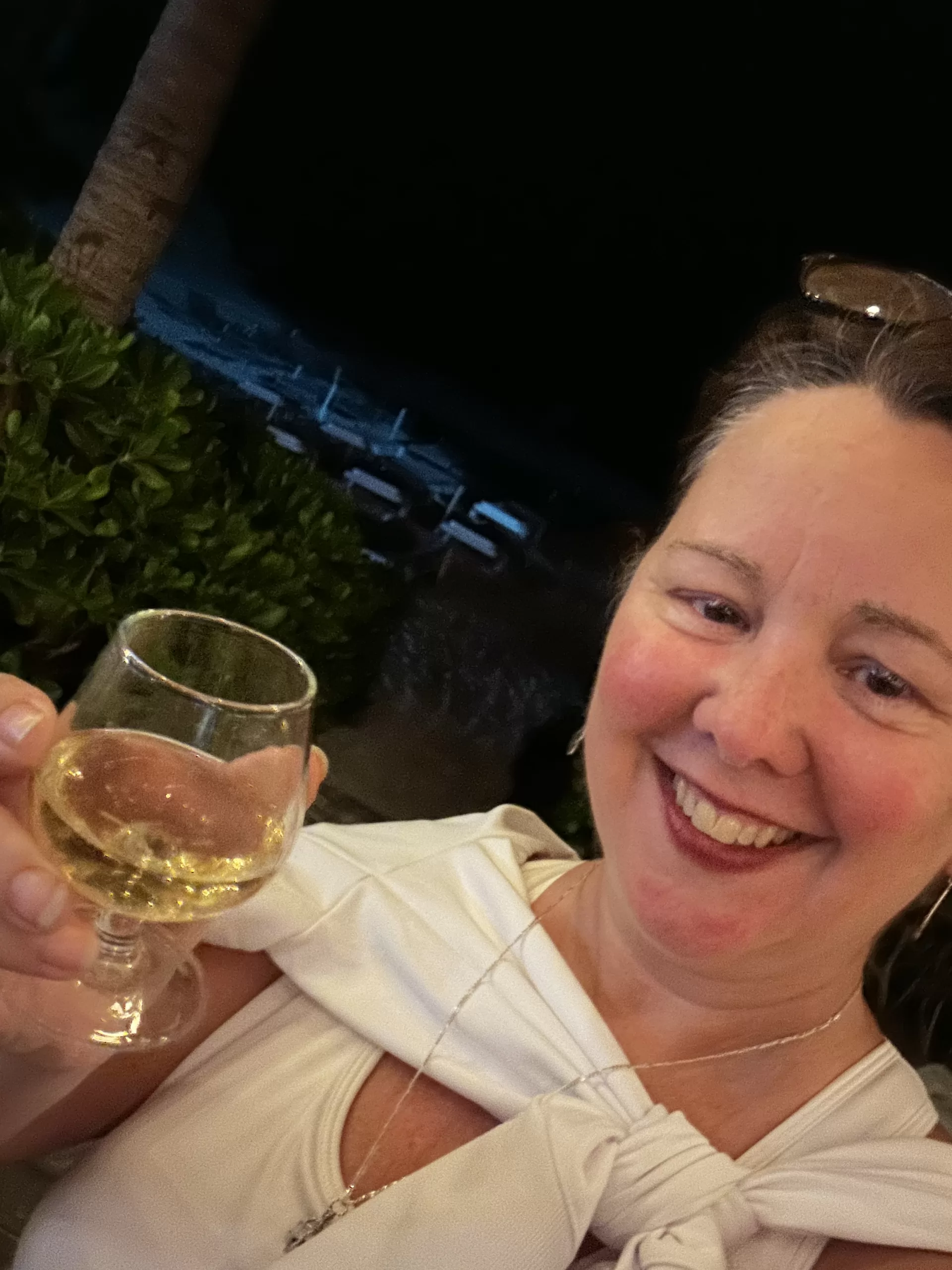 Bridget Espinosa holding a glass of alcohol, enjoying the evening at a beach club in Puerto Morelos.