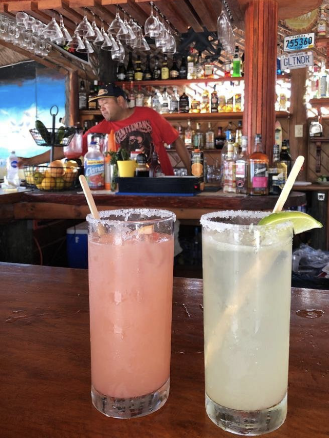 Two cocktails resting on the bar at Diving Lodge. One is a paloma and the other is a margarita, both made with tequila.