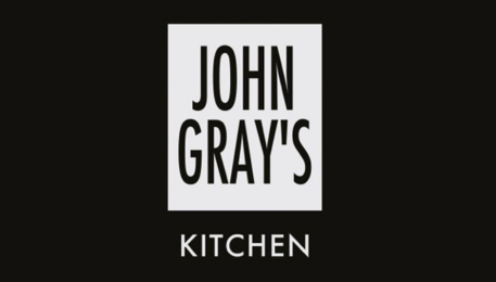 Black rectangle with a smaller white rectangle inside of it saying "John Gray's Kitchen"