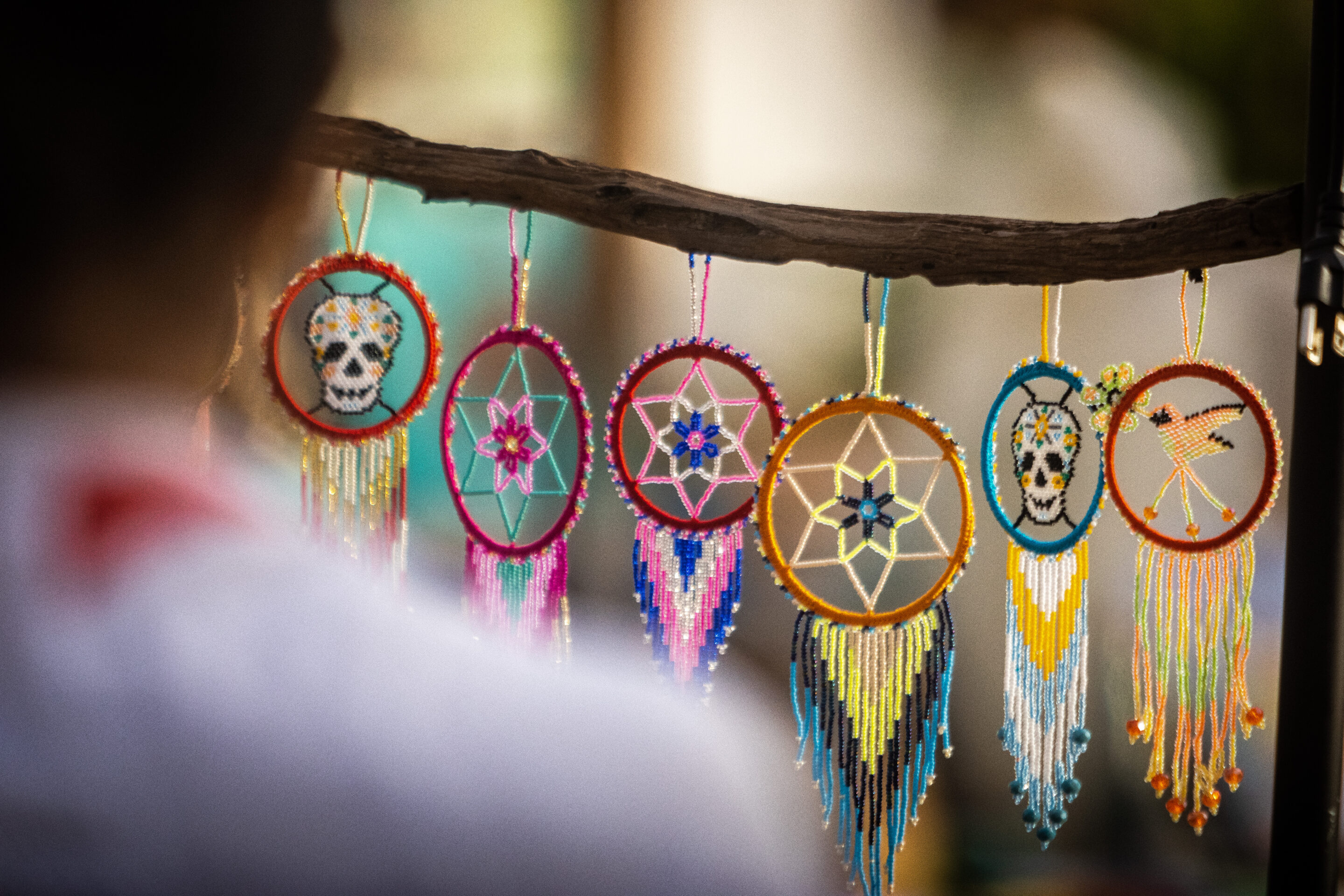 A photo of small dreamcatchers hanging in the market at the park on the port side of town.