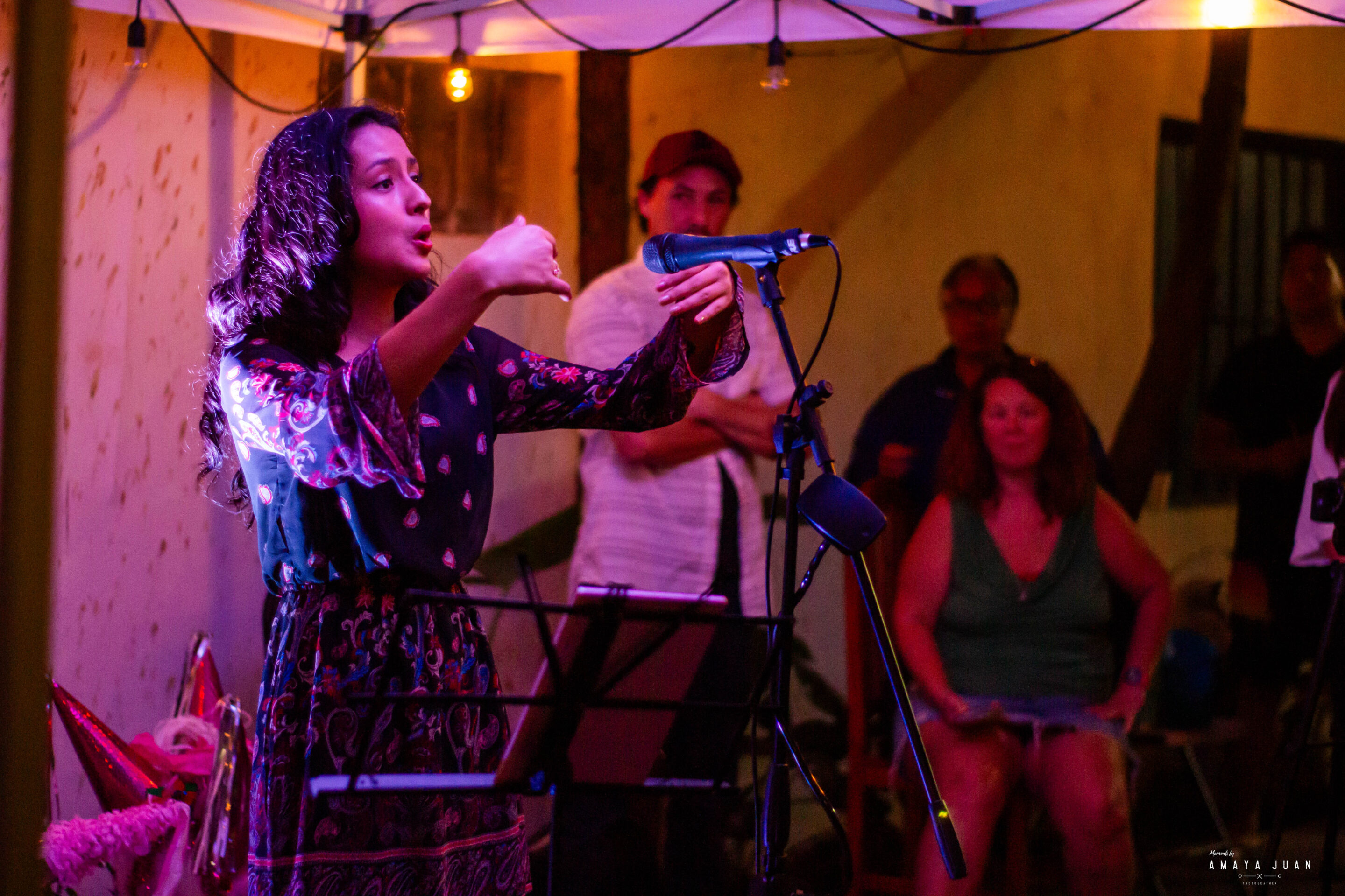 A woman speaks into a microphone at the El Telar and Experience Puerto Morelos Posada event on 12/22/23.